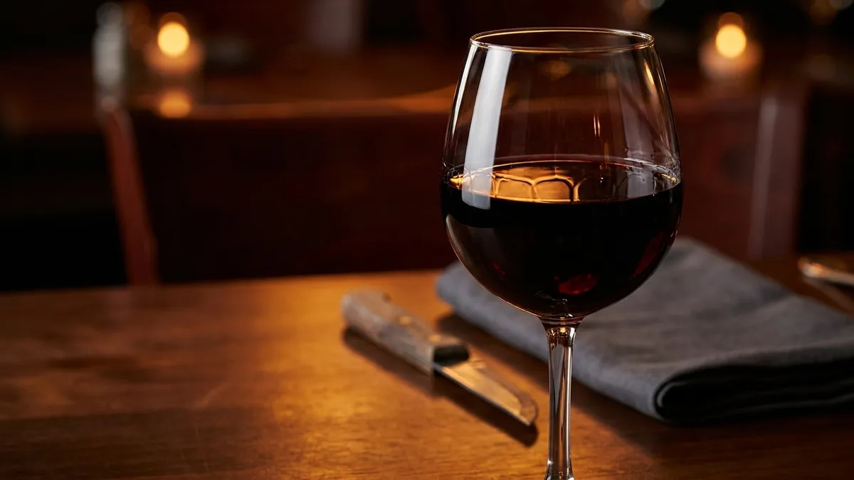 A bold high-ABV red wine in a large bowl glass on a dark backdrop